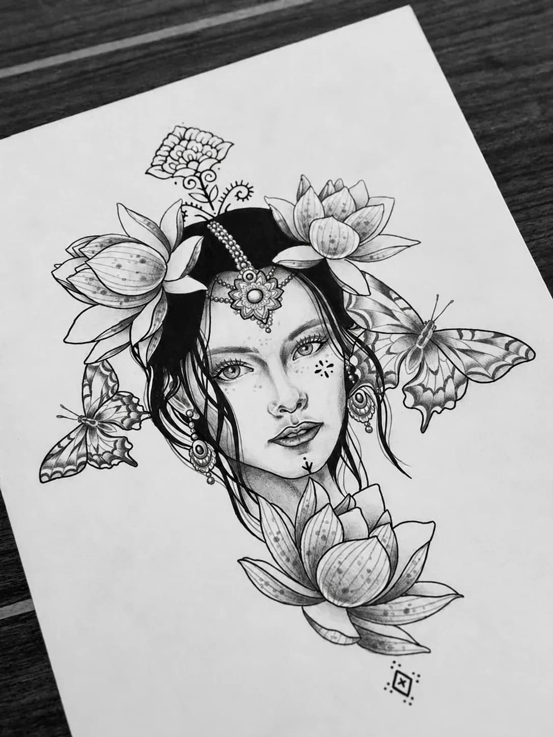 Ink drawing of a woman framed by lotus flowers and butterflies