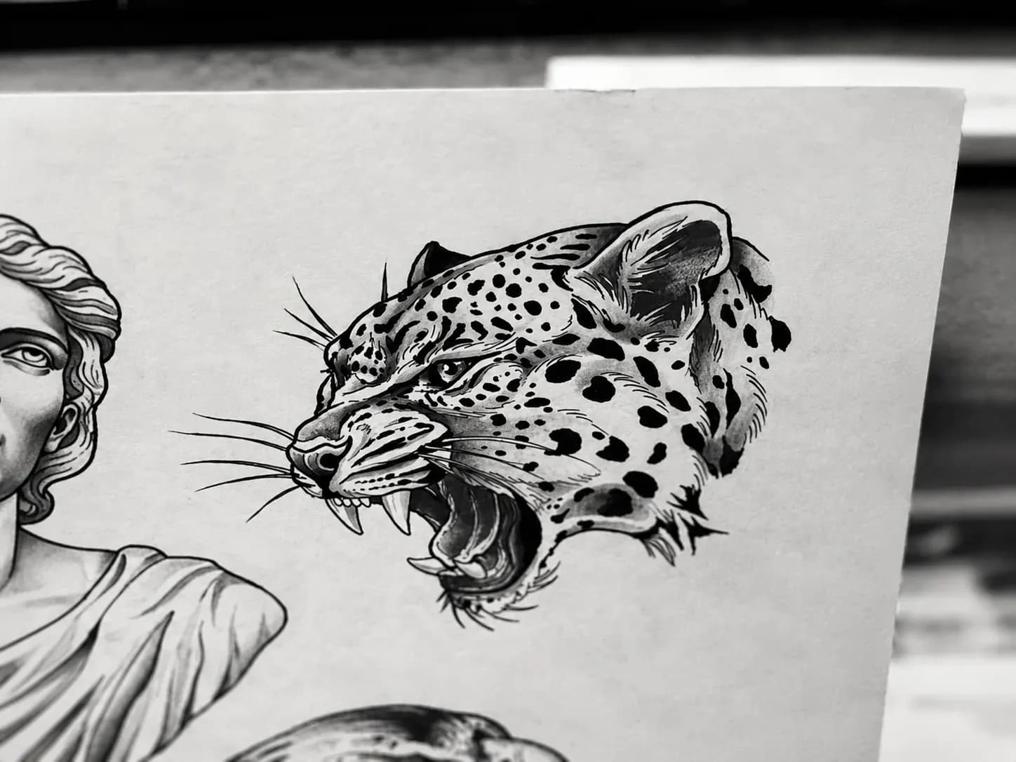 Ink drawing of a roaring leopard beside a classical bust